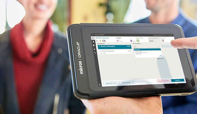 A front desk agent uses Oracle's 720 tablet to check in guests.