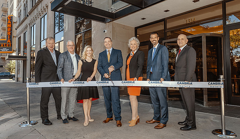 The ribbon-cutting at the new Cambria Hotel in Houston. From left to right: Nick Kellock, COO, Concord Hospitality Enterprises; Shawn Todd, managing partner/CEO, Todd Interests; Tara Howard, director, Todd Interests; Pat Pacious, president/CEO, Choice Hotels International; Janis Cannon, SVP of upscale brands, Choice Hotels International; Scott Oaksmith, SVP of finance/chief accounting officer, Choice Hotels International; and David Bush, executive director, Preservation Houston. Photo credit: pwlstudio.com.